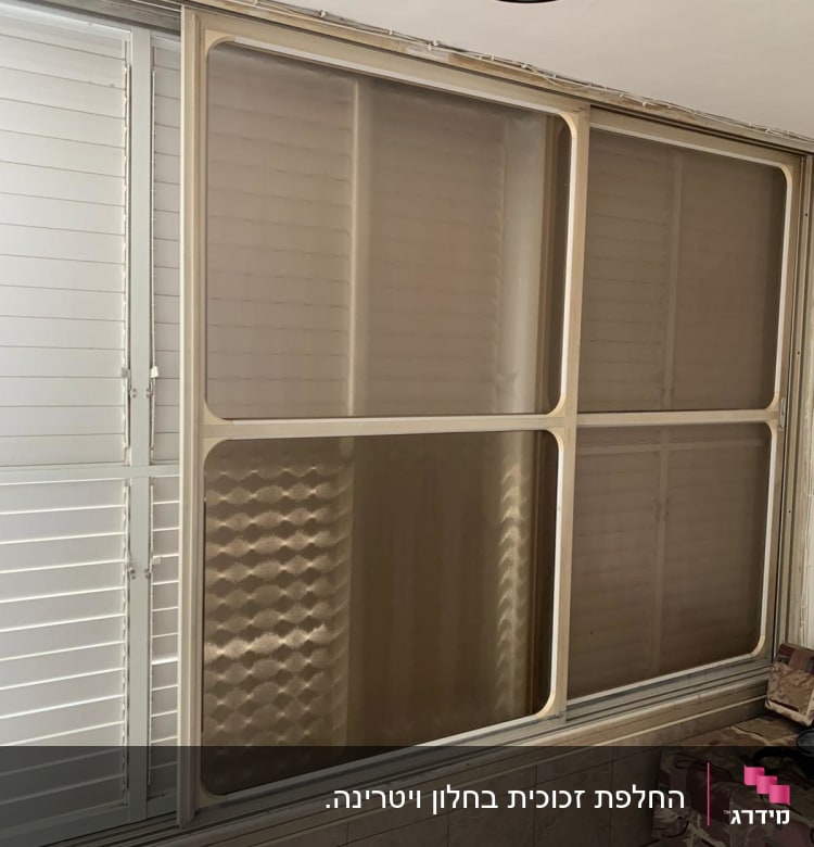 חלון זכוכית עם מסגרת מתכתית ודוגמה גיאומטרית